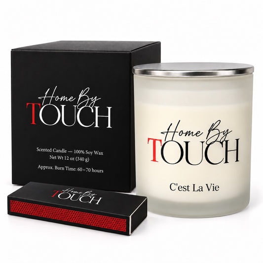 Home By TOUCH C’est La Vie 12 oz scented soy candle with silver lid, black signature box, and matches.