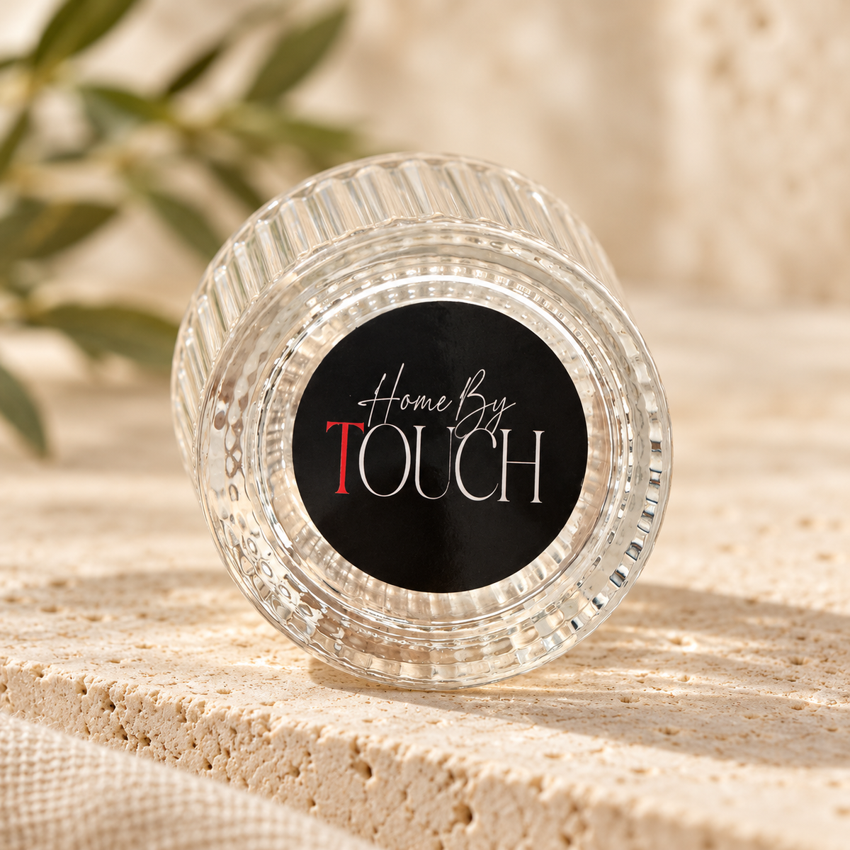 Home By TOUCH logo on the underside of the clear ribbed glass tea light holder.